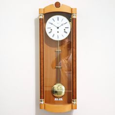 a wall mounted clock hanging on the side of a wall