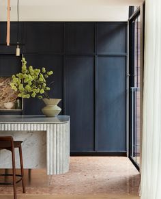 an elegant dining room with marble counter tops and black walls, along with wooden stools