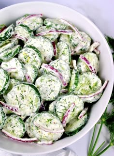 a white bowl filled with cucumber salad on top of a table