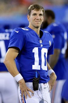 a close up of a football player on the field with his hands in his pockets