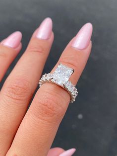 a woman's hand with a ring on it and a diamond in the middle