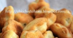 a pile of breaded pastries sitting on top of a white cloth covered table