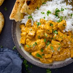 a bowl filled with rice and curry next to pita bread