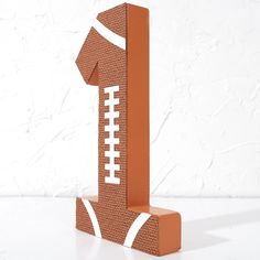 a paper sculpture of a football on top of a wooden block with the number one