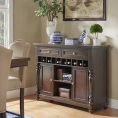 a sideboard with wine bottles and vases on it