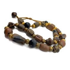 Rich browns and golds make these beads a real standout as a unique handmade necklace from the 1990s.  Each vintage bead is a different shape, some are painted, some are wrapped with gold thread.  Altogether they are a unique and subtle composition that will complement many a fashion choice.   The beads are strung on a gold satin cord that loops to make a  simple toggle closure with another bead from the necklace.  These are earth tones at their best!  The closer you look at the beads, the more style and art you can see, yet the unified look of the necklace is stunning and warm. Free next-day shipping Recycled Necklaces, Vintage Rhinestone Necklace, Brown Jewelry, Brown Necklace, Moon Pendant Necklace, Gold Satin, Shades Of Brown, Gold Thread, Dragon Pendant