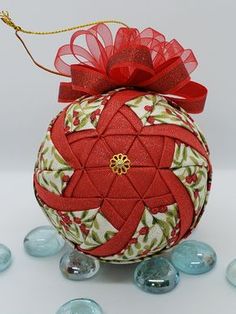 an ornament with a red bow on top of some blue glass balls and beads