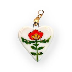 Discover the charm and elegance of these hand-painted porcelain heart pendants, crafted with care and adorned with intricate designs that speak to the soul. Each pendant is a miniature work of art, fired three times at 1200oC to achieve a durable and lustrous finish. Choose from four unique designs: *A: A bold and striking design featuring a black and red ladybug amidst delicate green foliage, accented with tiny gold details. *B: A sweet and simple strawberry motif, surrounded by tiny golden dots, perfect for adding a touch of whimsy to your collection. *C: A vibrant red flower with intricate green leaves, bringing a pop of color and a touch of nature's beauty to any outfit. *D: A mysterious keyhole design, surrounded by red flowers and green leaves, symbolizing secrets and adventures yet Hand Painted White Heart Jewelry, White Hand Painted Heart Jewelry, Porcelain Heart, Symbol Jewelry, Necklace Ceramic, Love Symbol, Romantic Boho, Ceramic Necklace, Heart Pendants