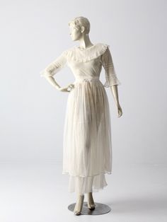 This an antique white dress from the late Victorian period. The sheer white dress features a ruffled neckline, three quarter sleeves, and a long skirt that wraps to create tiers. The bodice of the dress hooks to the skirt.  CONDITION The fair condition.  There are some holes in the bodice. There is wear around the waistband with snap closures missing. Currently held with safety pins. MEASUREMENTS Approximate FitXS Bust                     33"  ...  83.8 cm Waist              23"  ...   58.4 cm L Victorian Vintage Lace Dress With Ruffles, Elegant Vintage White Victorian Dress With Ruffles, White Vintage Dress With Ruffles For Evening, White Ruffled Vintage Evening Dress, Vintage White Victorian Day Dress With Ruffles, Daywear Victorian Lace Dress With Ruffles, Vintage White Victorian Dress With Ruffles For Daywear, Daywear Lace Victorian Dress With Ruffles, Lace Victorian Dress With Ruffles For Daywear