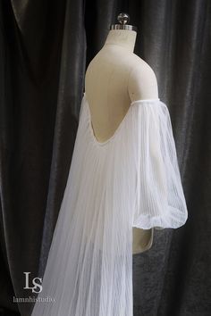 a mannequin wearing a white dress with long sleeves