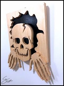 a carved wooden skull with spikes and wings on it's head is mounted to the wall