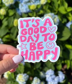 someone holding up a sticker that says it's a good day to be happy