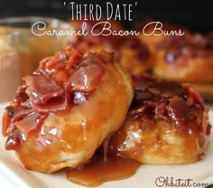 two glazed bacon buns sitting on top of a white plate