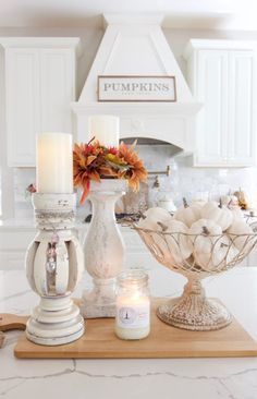 a kitchen counter with candles and pumpkins on it