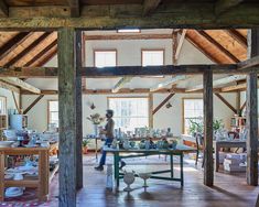 a person standing in a room with wooden beams