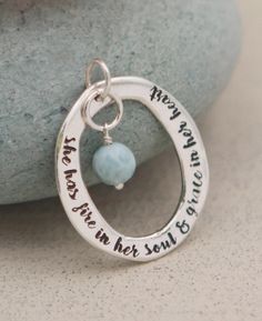 You've got a special spark inside, a flame that warms your heart and makes you shine with determination. No one can dull that fire, at least, not as long as you wear this dynamic pendant. Its sterling silver "O" ring is cast with hand-molded details and dangles with a soothing larimar gemstone bead. Larimar is said to inspire serenity and calm, so you can stay cool even as you burn bright. The pendant's ring measures 1.25 inches long and 1 inch wide. Inspirational beaded charm pendant "She has f Spiritual Hand Stamped Sterling Silver Jewelry, Hand Stamped Spiritual Sterling Silver Jewelry, Handmade Meaningful Sterling Silver Jewelry, Handmade Sterling Silver Meaningful Jewelry, Inspirational Handmade Sterling Silver Jewelry, Handmade Inspirational Sterling Silver Jewelry, Hand Stamped Sterling Silver Oval Pendant, Sterling Silver Hand Stamped Oval Pendant Jewelry, Buddha Groove