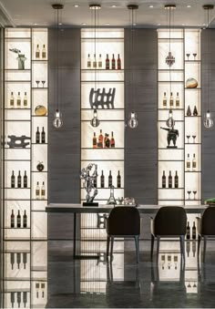 a room filled with lots of bottles and chairs next to a wall mounted wine rack