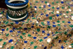 a spool of thread sitting on top of a table covered in sequins