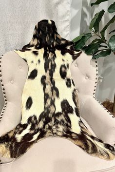 the back of a chair with an animal print rug on it's seat cushion