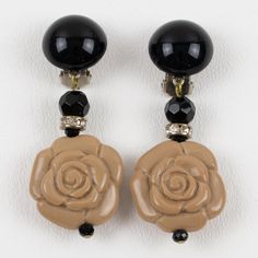 This is part of Chairish’s Costume Jewelry assortment.  Charming resin clip-on earrings designed by Angela Caputi, made in Italy. Dangling shape with black color contrasted with a carved toffee beige resin floral element and complemented with tiny clear rhinestones spacer rings.  As you know, Caputi jewelry is not signed. This is a pre-owned pair of earrings, and the branded plastic tag was removed.  Measurements: 2.44 in long (6.2 cm) x 1 in wide (2.5 cm).  Please see the measurements noted abo Spacer Rings, Ring Spacer, Flower Resin, Black And Beige, Clip Earrings, Clear Rhinestones, Toffee, Designer Earrings, Costume Jewelry