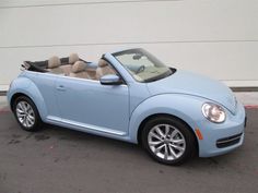 a blue convertible car parked in front of a building