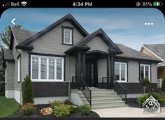 a gray house with white windows and stairs