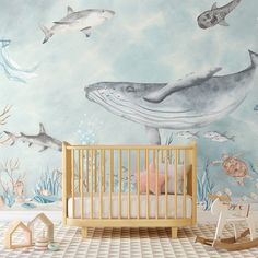 a baby's room with a mural of dolphins and other marine creatures on the wall