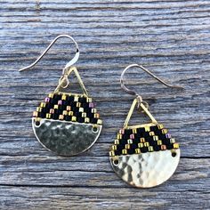 two pairs of earrings sitting on top of a wooden table