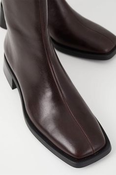 Vagabond Blanca square toe boots in beautiful chocolate brown leather. The smooth leather upper is set on contrast-colored outsoles, complemented with flared block heels for a contemporary look. The square toes and mid-shaft provides a modern, refined take on a classic style. Details include zip-side fastening and visible seams along the front. True to size Shaft height: 189 mm, shaft width: 253 mm, heel height: 47 mm 5217-201-35 PIPE AND ROW 90s Boots, Vagabond Shoes, Clogs Heels, Neutral Shoes, Style Goals, Chocolate Leather, Cream Shoes, Square Toe Boots, Toe Boots