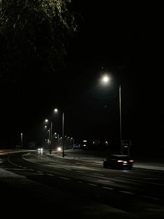 a car driving down the road at night