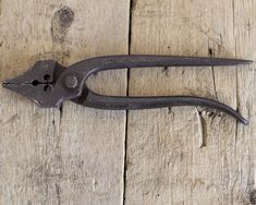 an old pair of pliers sitting on top of a wooden table