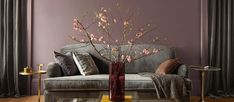 a living room with a couch, table and vase filled with flowers on the coffee table