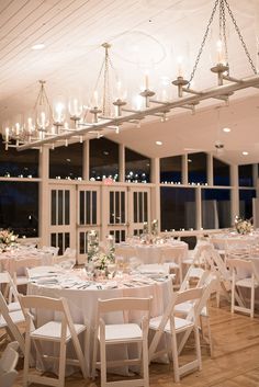 a room filled with lots of white tables and chairs