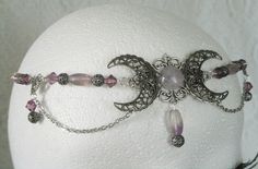 "Fluorite Triple Moon Goddess Circlet This beautiful circlet has purple Czech glass beads, fluorite beads, sterling silver plated filigree beads, sterling silver plated accents, sterling silver plated chain and sterling silver plated triple moon pendant with fluorite setting. 20\" long can be adjusted to 24\". Sterling silver plated lobster clasp." Adjustable Purple Moon Phase Jewelry, Mystical Purple Jewelry For Festivals, Bohemian Amethyst Moon Phase Jewelry, Adjustable Wire Wrapped Fantasy Jewelry, Purple Crescent Bohemian Jewelry, Bohemian Purple Crescent Jewelry, Dragons Breath Fire Opal, Witchcraft Magic, Wicca Jewelry