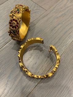 Temple bangle in matte gold and ruby stone. Detailing has the Rajasthani similarity. About an inch wide. Disclaimer: Price listed is for a single Kada. If you want to get them in a pair please select quantity 2. Heavy Brass Bangle For Festive Occasions, Gold Ruby Bracelet In Temple Jewelry Style, Gold Ruby Bracelets In Temple Jewelry Style, Festive Brass Bangle Bracelets, Traditional Gold Bangle With Ruby, Traditional Gold Ruby Bangle, Festive Gold Ruby Bracelets, Gold Ruby Toe Ring Jewelry, Gold Jeweled Brass Bracelet