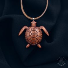 This turtle pendant is made from rare Bubinga wood, making it unique and particularly attractive. Each pendant is handcrafted with high attention to detail and precision, which adds to its uniqueness and elegance. The turtle, which is a symbol of wisdom, stability, and longevity, makes this pendant a perfect gift for those who strive for success and stability in life.    [CARE] The pendant is sealed with two or more layers of wood oil in order to protect the wood against moisture and the environ Handmade Mahogany Jewelry For Gift, Handmade Mahogany Necklace For Gift, Mahogany Handmade Jewelry For Gift, Handmade Mahogany Jewelry Gift, Mahogany Wooden Beads Jewelry For Gifts, Wooden Pendant Necklace For Gift, Unique Carved Brown Necklace, Natural Wood Pendant Necklace, Nature-inspired Carved Pendant Jewelry