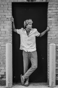 black and white photograph of a man standing in front of a door