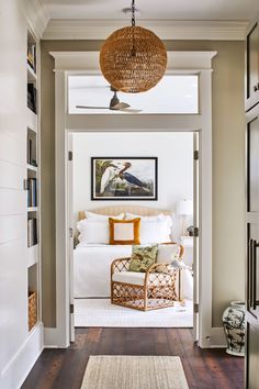 a living room filled with furniture and a large lamp hanging from the ceiling next to a doorway