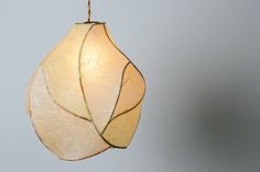 a light hanging from a ceiling with a leaf design on it