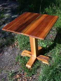 a wooden table sitting on top of a lush green field