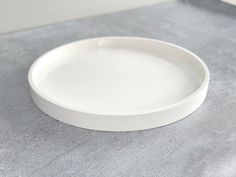 a white plate sitting on top of a counter next to a knife and fork,