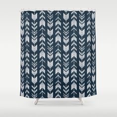 a blue and white shower curtain with an arrow pattern on the bottom, in front of a