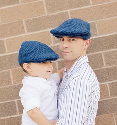 a man holding a little boy wearing a blue hat