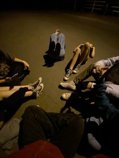 four people sitting in a circle on the ground