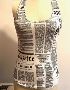 John Galliano newspaper sleeveless T-shirt, tank top product details Dress Form is Size 6 measures while flat: 16 1/2 inches under arms across front 21 inches from top of shoulder to bottom 12 inches from under arm to bottom seam Dry clean.  Thank you for supporting small business  VISIT MY SHOPS HERE   * http://www.etsy.com/shop/HappyCatHouse * http://www.Etsy.com/shop/AnEnchantingCreature  CONNECT  * http://www.facebook.com/EnchantingCreature * https://instagram.com/enchantingcreature * https: Printed Stretch Cotton Tank Top, Stretch Cotton Printed Tank Top, Fitted Sleeveless Graphic Print T-shirt, Sleeveless Cotton T-shirt With Print, Sleeveless Cotton T-shirt With Printed Design, Sleeveless Cotton Printed T-shirt, Cotton Tank Top With Graphic Print, Cotton Graphic Print Top With Tank Straps, Printed Fitted Cotton Tank Top