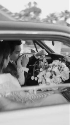 the bride and groom are sitting in their wedding car talking on the phone as they look at each other