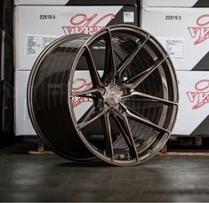 a close up of a tire on a floor with boxes in the backgroud