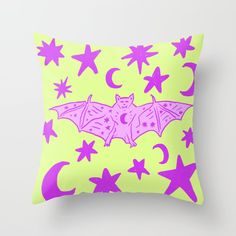 a pink bat with stars and crescents on a yellow background is featured in this pillow case