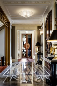 an elegant foyer with marble floors and chandeliers