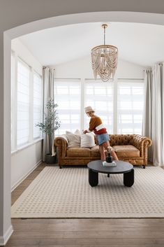 a teddy bear sitting on top of a coffee table in a living room next to a couch